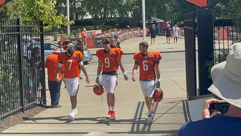 Joe Burrow (center) walks to practice Wednesday with fellow quarterbacks Jake Browning (right) and Will Grier. Laurel Pfahler/CONTRIBUTED