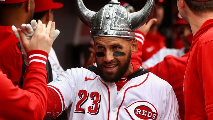 Nick Martini, of the Reds, celebrates with teammates in the dugout after hitting a two-run home run in the second inning on Opening Day on Thursday, March 28, 2024, at Great American Ball Park in Cincinnati. David Jablonski/Staff