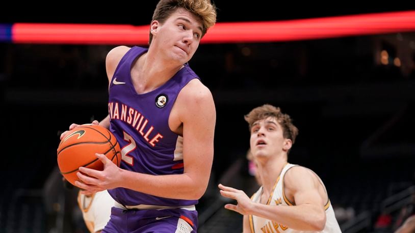 Evansville's Blake Sisley, left, looks to the basket as Valparaiso's Preston Ruedinger defends during the second half of an NCAA college basketball game in the first round of the Missouri Valley Conference tournament Thursday, March 3, 2022, in St. Louis. (AP Photo/Jeff Roberson)