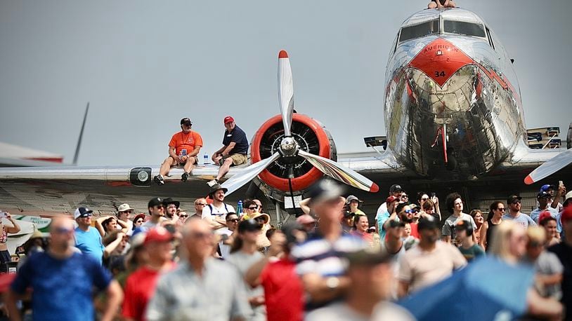 Patrons sit on the wings of the planes at the Dayton Air Show Sunday, July 23. MARSHALL GORBY/STAFF