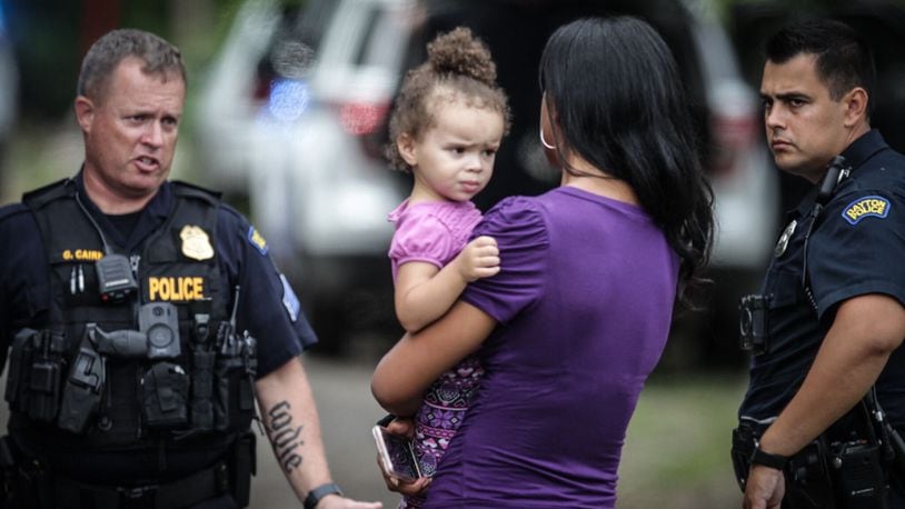 Police officers talk with Razshae Wood after she was reunited with her daughter, Haleigh, after the girl was found Thursday, Aug. 27, 2020. A thief took the car from a Dayton gas station, but the 2-year-old was sitting in the back seat. The girl was found by an Amazon driver on the side of a street in her carrier later. JIM NOELKER/STAFF