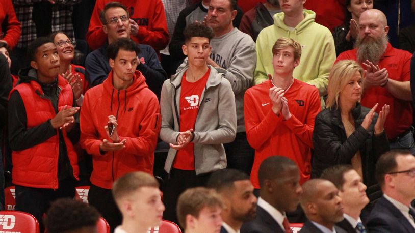 Koby Brea, center, stands behind the Dayton bench next to Lukas Frazier, second from right, during a game against Indiana State on Nov. 9, 2019, at UD Arena. David Jablonski/Staff