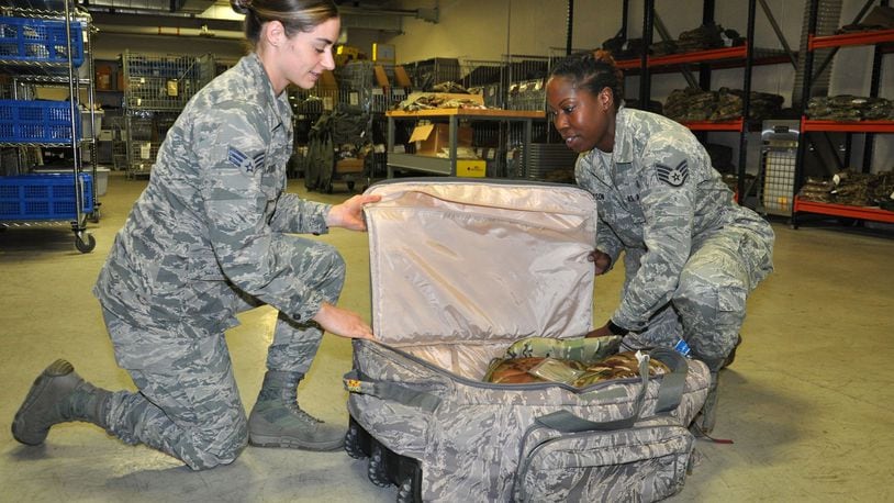 Senior Airman Emily Killingbeck, a unit deployment technician with the 88th Medical Support Squadron, and Staff Sgt. Jeria Dotson, medical readiness training manager, build up a deployment bag at the 88th Medical Readiness Squadron s medical readiness warehouse July 6. (U.S. Air Force photo/Bryan Ripple)