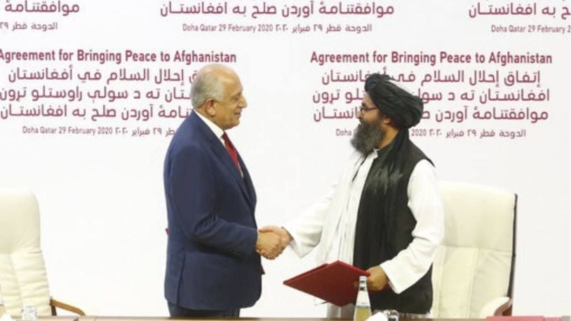 U.S. peace envoy Zalmay Khalilzad, left, and Mullah Abdul Ghani Baradar, the Taliban group's top political leader shake hands after signing Saturday's agreement.