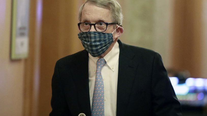 In this April 16, 2020, file photo wearing his protective mask made by his wife, Ohio Gov. Mike DeWine walks into his daily coronavirus news conference at the Ohio Statehouse in Columbus, Ohio. (Doral Chenoweth/The Columbus Dispatch via AP)