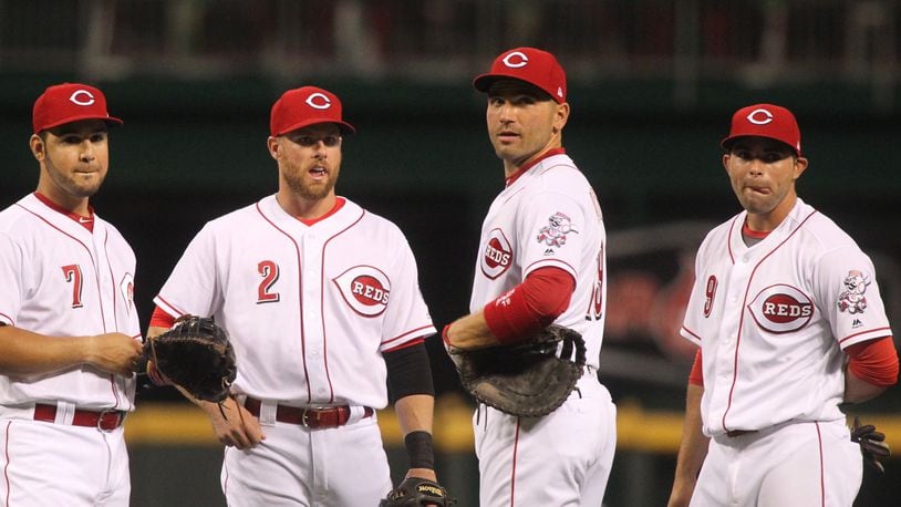 Reds infielders Eugenio Suarez, Zack Cozart, Joey Votto and Jose Peraza talk during a review during a game against the Cardinals on April 20, 2017, at Great American Ball Park in Cincinnati. David Jablonski/Staff