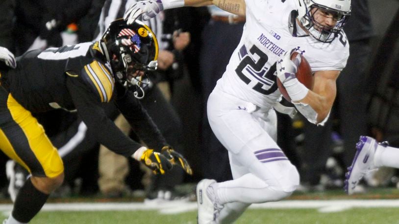 IOWA CITY, IOWA- NOVEMBER 10: Running back Isaiah Bowser #25 of the Northwestern Wildcats breaks a tackle in the second half by defensive back Amani Hooker #27 of the Iowa Hawkeyes, on November 10, 2018 at Kinnick Stadium, in Iowa City, Iowa. (Photo by Matthew Holst/Getty Images)