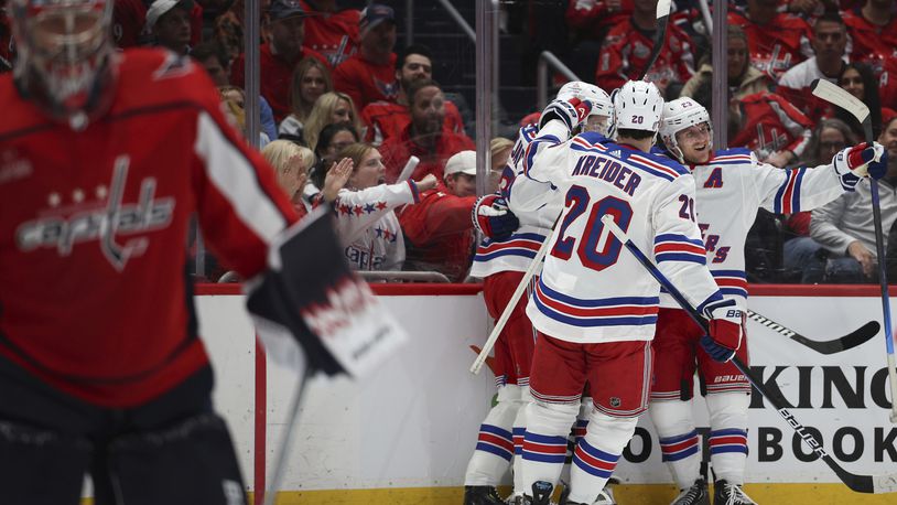 New York Rangers defenseman Adam Fox (23) celebrates with teammates after a goal against the Washington Nationals by center Vincent Trocheck (16) during the second period in Game 3 of an NHL hockey Stanley Cup first-round playoff series, Friday, April 26, 2024, in Washington. (AP Photo/Tom Brenner)
