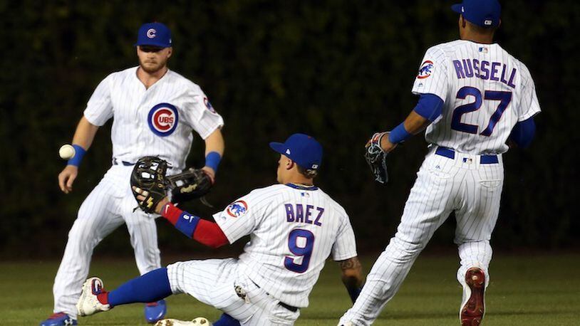 Chicago Cubs center fielder Ian Happ, second baseman Javier Baez (9), and shortstop Addison Russell (27) surround a double by the Cincinnati Reds' Jose Peraza during the fourth inning at Wrigley Field in Chicago on Tuesday, May 16, 2017. (Nuccio DiNuzzo/Chicago Tribune/TNS)
