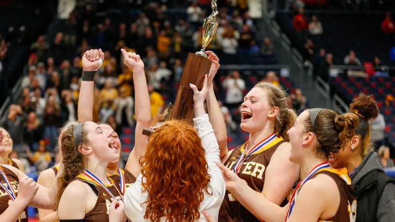 The Alter High School girls basketball team hoists the trophy after beating Thornville Sheridan 54-38 on Saturday afternoon at UD Arena to win its first state championship since 2017. CONTRIBUTED PHOTO BY MICHAEL COOPER