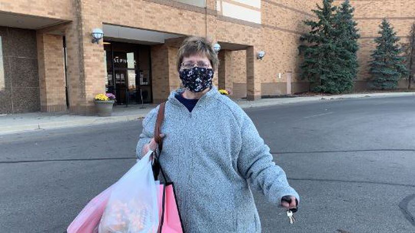 Robine Baker of Dayton wears a mask as she exits JC Penny at the Mall at Fairfield Commons.
