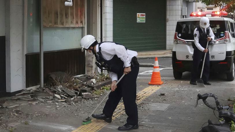 Police officers clean the debris from an earthquake in Uwajima, Ehime prefecture, western Japan Thursday, April 18, 2024. According to Kyodo News reports, a strong earthquake hit Ehime and Kochi prefectures in western Japan on Wednesday night, but no tsunami warning was issued. (Kyodo News via AP)
