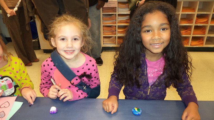 Whitney Officer (left) and Jalina Watson, Primary Village South first-graders, pose with the Peace Rocks they created at Peace Night on Nov. 21. CONTRIBUTED