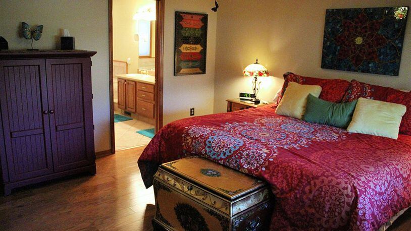 The main-floor bedroom suite is updated with hardwood flooring. Oak casings frame the double window and a designer paddle fan centers the ceiling.