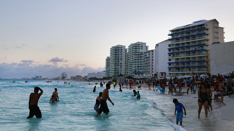 Beachgoers wade on the beach in Cancun, Mexico, on April 4, 2015. (Photo: Cassi Alexandra/Bloomberg)