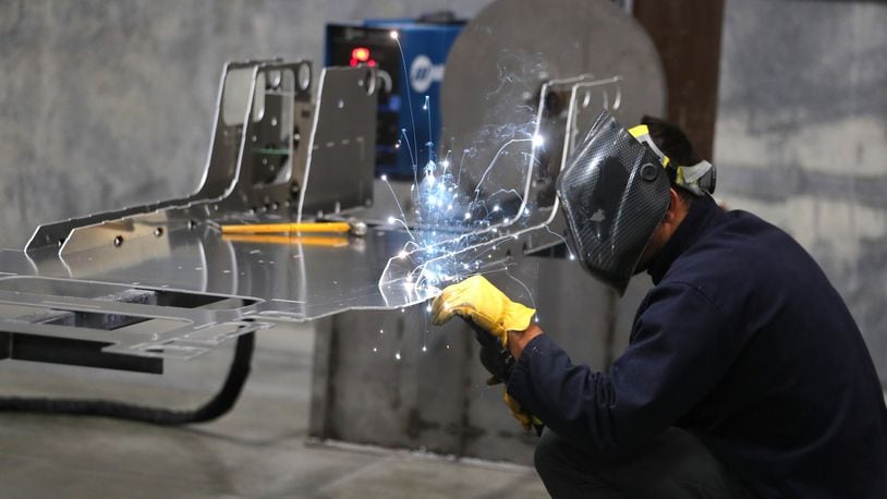 A worker welds a custom built aluminum body frame for a Venice roadster model vehicle at the Vanderhall Motor Works manufacturing facility in Provo, Utah. GEORGE FREY / BLOOMBERG
