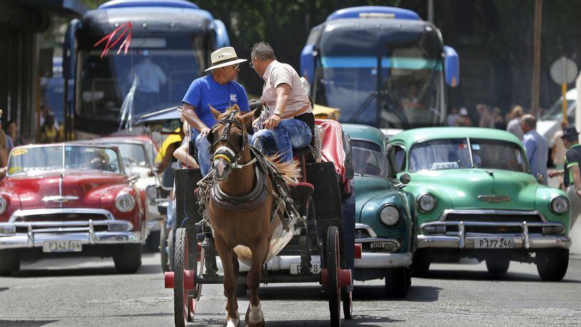 Tourist buses share the road along with vintage American cars and a horse drawn buggy in Havana, Cuba, in March 2016. (Al Diaz/Miami Herald/TNS)