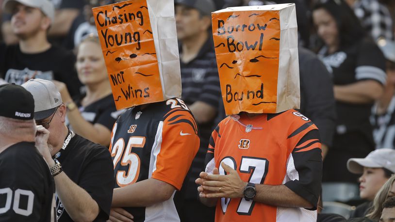 Cincinnati Bengals fans wear paper bags on their heads during the second half of an NFL football game against the Oakland Raiders in Oakland, Calif., Sunday, Nov. 17, 2019. (AP Photo/Ben Margot)