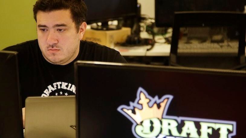 In this Sept. 9, 2015, file photo Len Don Diego, marketing manager for content at DraftKings, a daily fantasy sports company, works at his station at the company's offices in Boston. The daily fantasy sports industry has contracted starkly since questions about the legality of online games offered by companies sparked court and legislative battles across the U.S. last year. (AP Photo/Stephan Savoia, File)