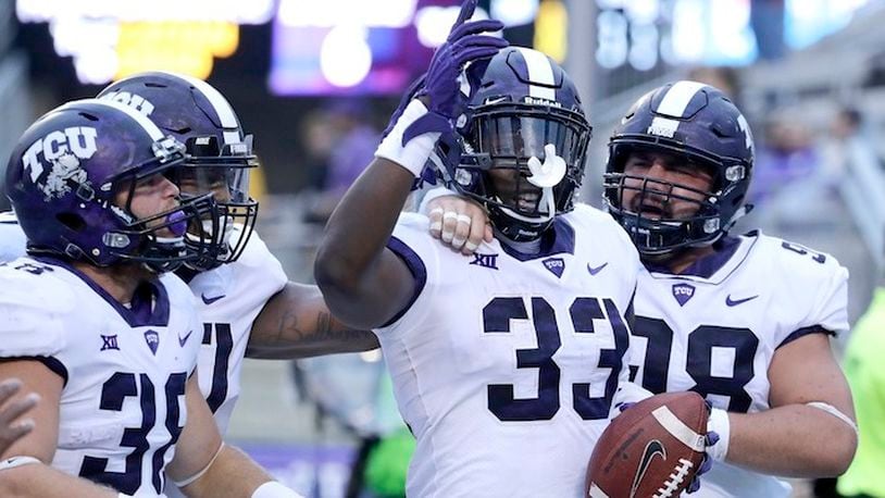 TCU running back Sewo Olonilua (33) celebrates with teammates after scoring a touchdown during the second half of an NCAA college football game against Kansas State Saturday, Oct. 14, 2017, in Manhattan, Kan. TCU won 26-6. After two weather delays, the game ended 7 hours and 15 minutes after the scheduled start time. (AP Photo/Charlie Riedel)