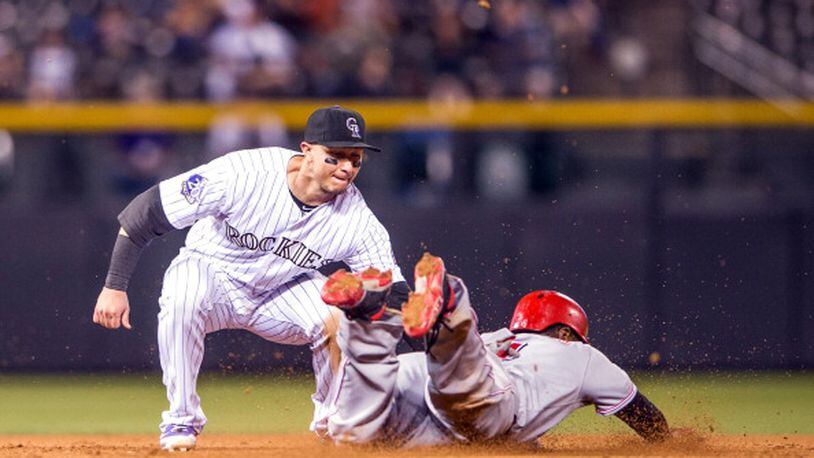 DENVER, CO - AUGUST 30: Brandon Phillips #4 of the Cincinnati Reds slides in safely to second base on a wild pitch under a tag attempt by Troy Tulowitzki #2 of the Colorado Rockies during the ninth inning of a game at Coors Field on August 30, 2013 in Denver, Colorado. The Rockies beat the Reds 9-6. (Photo by Dustin Bradford/Getty Images)