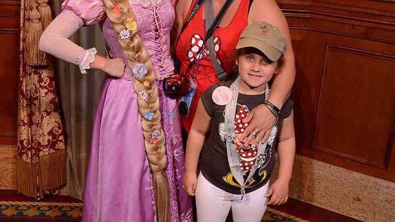Aviana Finton and her mother, Corri, pose with Rapunzel at Walt Disney World. CONTRIBUTED