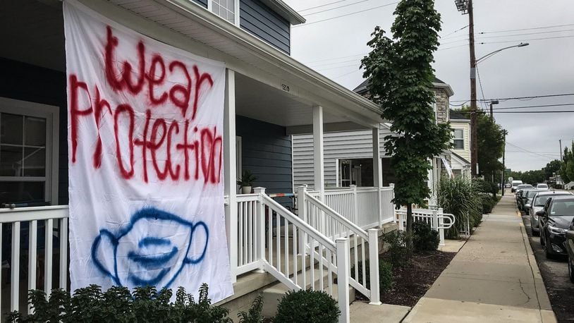 A sign on the University of Dayton housing in March 2020 urges mask wearing. FILE