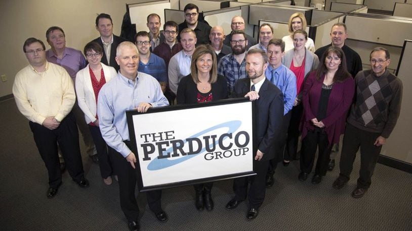A 2016 photo of Beavercreek’s Perduco Group workforce. The company that year was more than doubling its space off Pentagon Boulevard. The firm specializes in “big, ugly data, ” in defense, in health care and yes, in sports and fantasy football. Execs with the sign from the left are: Chris Mason VP Operations, Toyzanne Mason, President, and Stephen Chambal, VP.