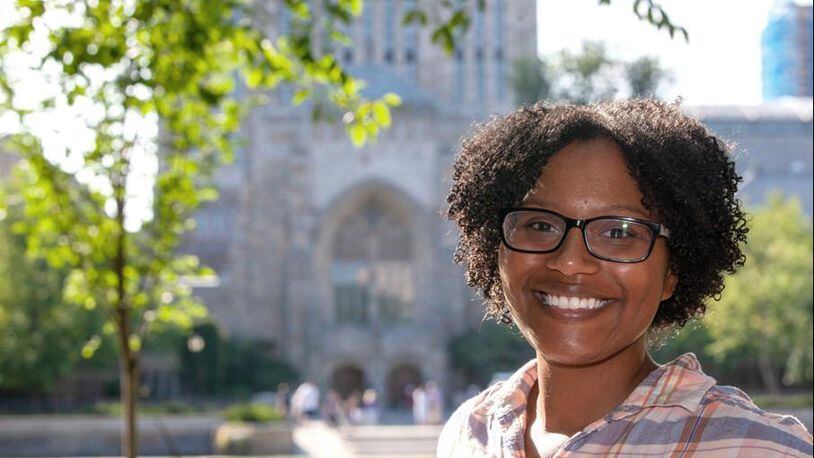 Chelesa Fearce, a Clayton County student who overcame homelessness to become her high school class valedictorian in 2013, stands in front of the Sterling Memorial Library at Yale University.