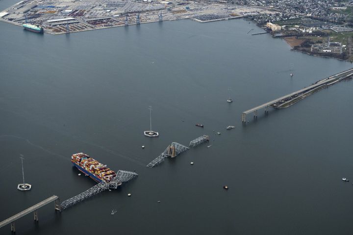 
                        An aerial view of the Dali container ship with a collapsed section of the Francis Scott Key Bridge across its bow after it collided with the bridge early Tuesday morning and the Dundalk Marine Terminal in the background in Baltimore, Md., on Tuesday, March 26, 2024. Six construction workers who had been fixing potholes on the Francis Scott Key Bridge remained missing as divers and other emergency workers on boats and helicopters continued to search for them. Two others had been rescued. (Erin Schaff/The New York Times)
                      