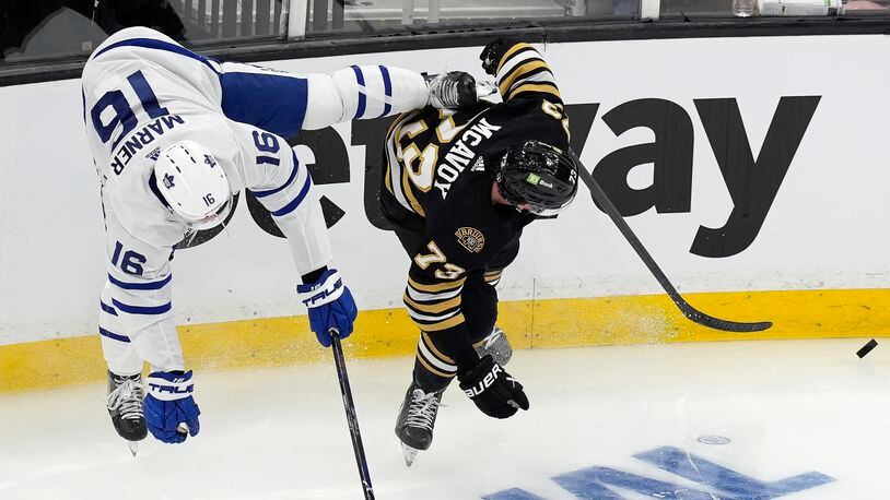 Toronto Maple Leafs' Mitch Marner (16) and Boston Bruins' Charlie McAvoy (73) compete for the puck during the first period in Game 1 of an NHL hockey Stanley Cup first-round playoff series, Saturday, April 20, 2024, in Boston. (AP Photo/Michael Dwyer)