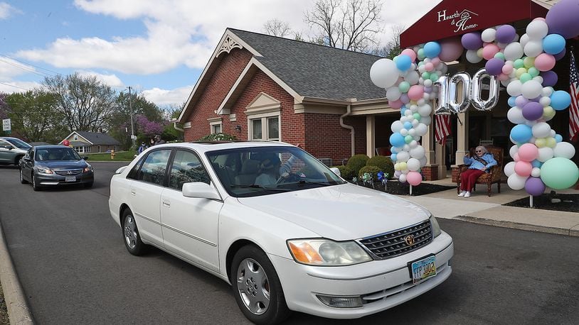 The car parade in Huber Heights will celebrate Wayne High School’s gradution. Pictured is a car parade for Ruth Bayley’s 100th birthday. Friends and family drove past her in front of the Hearth & Home care center. BILL LACKEY/STAFF