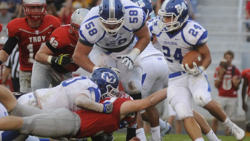 OSU recruit Josh Myers (58) overcame an early ankle injury and helps pave the way for running back Tony Clark. Miamisburg defeated Troy 21-17 in a Week 5 high school football GWOC crossover game at Troy’s Memorial Stadium on Friday, Sept. 23, 2016. MARC PENDLETON / STAFF
