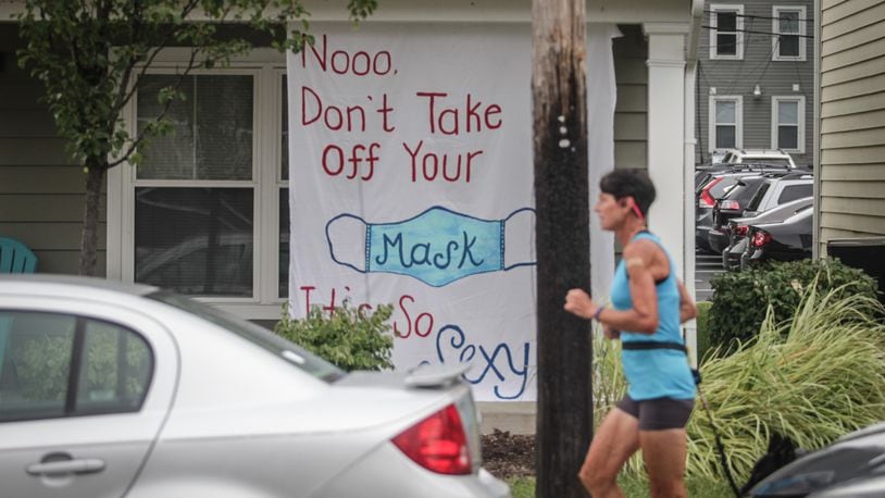A jogger runs by UD housing that is sending a message to other students.