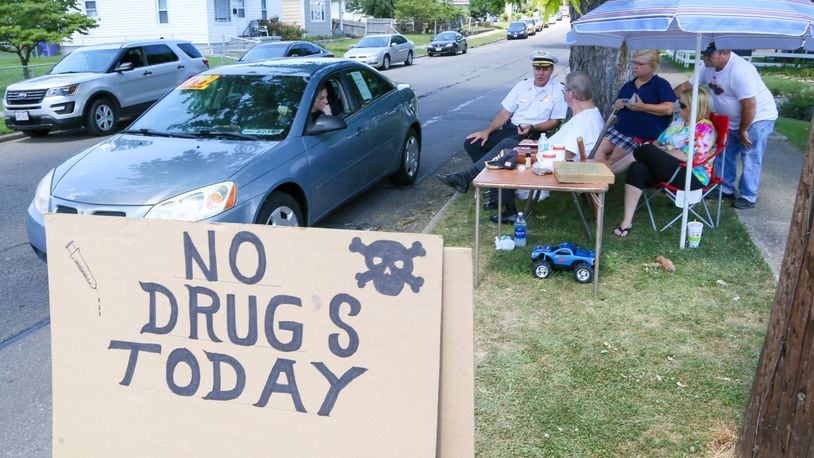 Hamilton Police Chief Craig Bucheit talks with Parkamo Ave. resident Denny Matheny who decided to place a sign outside his house in an effort to curb drug use in the neighborhood. Matheny was joined throughout the day by various neighbors family members. GREG LYNCH / STAFF