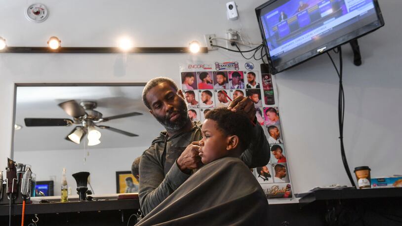 A barber giving a boy a haircut.