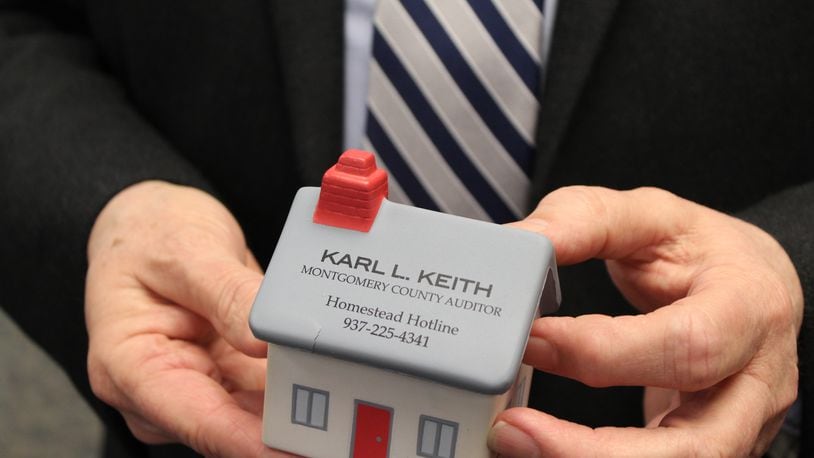 Montgomery County Auditor Karl Keith holds a foam desktop toy with the phone number citizens can call to learn more about the homestead exemption program. CORNELIUS FROLIK / STAFF