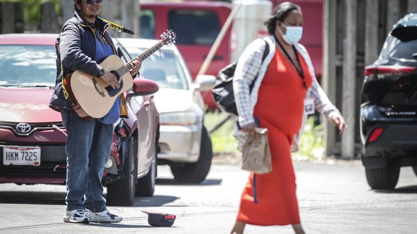 Stephen Jupiter plays music for tips behind Chipotle on Brown St. Thursday May 13, 2021 Soon Ohio may lift health orders on mask wearing inside and outside. JIM NOELKER/Staff.