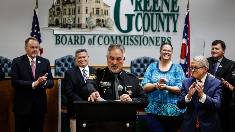 Greene County Sheriff Scott Anger talks about former sheriff Gene Fischer at the Greene County Board of Commissioners Friday, April 21, 2023. Ohio Gov. Mike DeWine, right, toured the Greene County Jail and announced a $15 million grant to support construction of a new jail. JIM NOELKER/STAFF