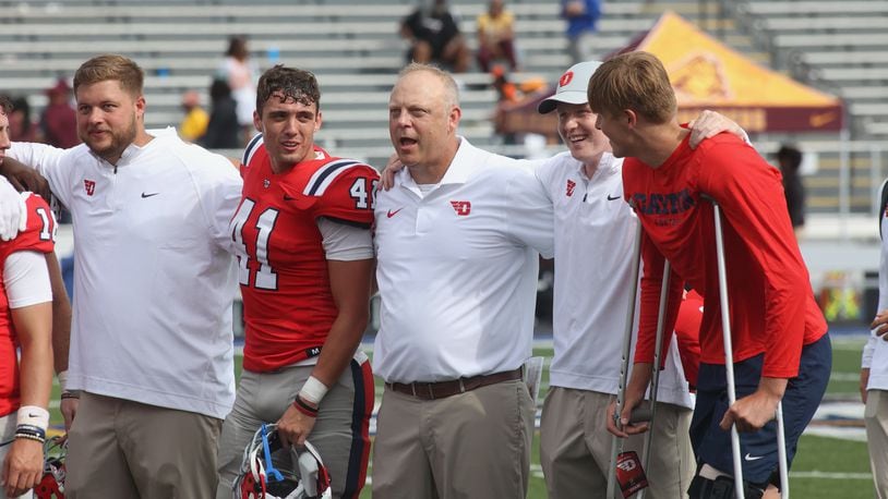 Dayton coach Trevor Andrews sings with the team after a victory against Central State on Saturday, Sept. 9, 2023, at Welcome Stadium. David Jablonski/Staff