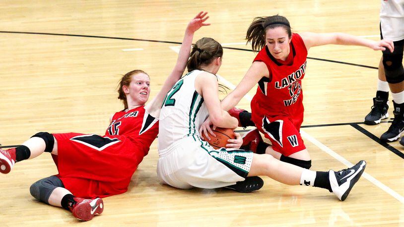 Lakota West’s Elisabeth Carter (left) and Lauren Cannatelli (right) fight for possession of a loose ball with Mason’s Jenna Gunn (32) during a Division I sectional game Feb. 24, 2014, at Lakota East. COX MEDIA FILE PHOTO