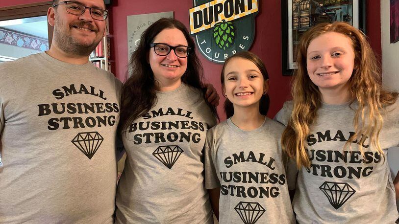 Sara Stathes owns Barrel House in downtown Dayton with her husband, Gus. She is in the center next to daughters and Ellie and Dylan.