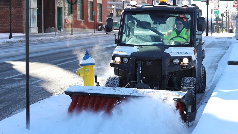 Snow removal crews, like this one in Springfield, have largely done their jobs, but cold temperatures could lead to more school closings. BILL LACKEY/STAFF