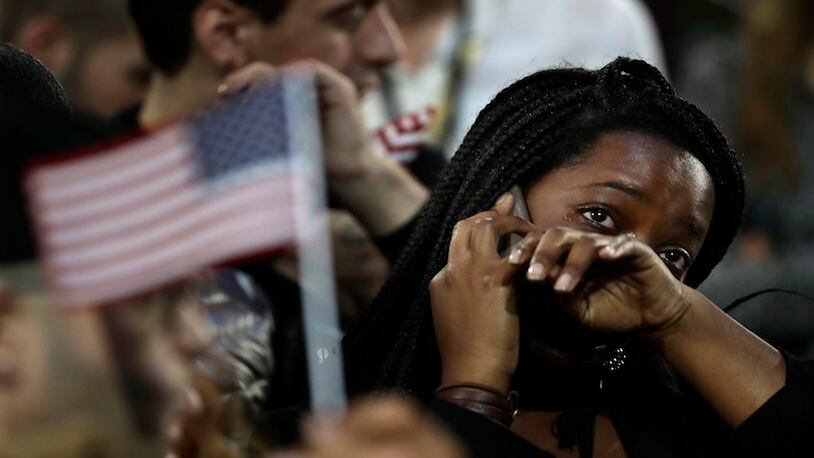 In this Nov. 8, 2016 file photo, a woman weeps as election results are reported during Democratic presidential nominee Hillary Clinton's election night rally in the Jacob Javits Center glass enclosed lobby in New York.  As Donald Trump approaches his inauguration as president, young Americans have a deeply pessimistic view about his incoming administration, with young blacks, Latinos and Asian Americans particularly concerned about whatâs to come in the next four years.  (AP Photo/Frank Franklin II)