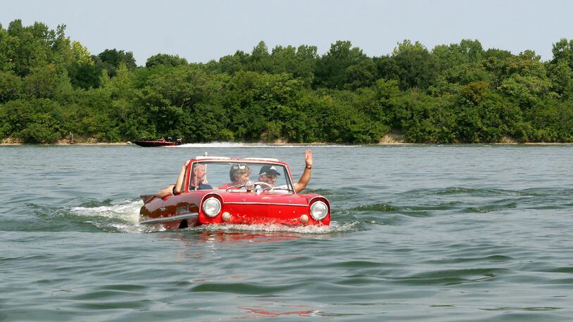 Mike Bayman waves to another boater as he takes a cruise in Eastwood Lake in his Amphicar during British Car Day 2007. Amphicars are powered by British-built Triumph engines. You can see a contingent of Amphicars as they take part in the Celina Lake Festival’s Grand Parade July 29. Skip Peterson photo