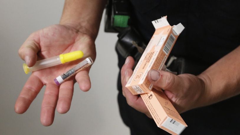 During his shift Tuesday, Dayton Police Department Officer Joe Sheen replenishes his supply of Narcan. CHRIS STEWART / STAFF