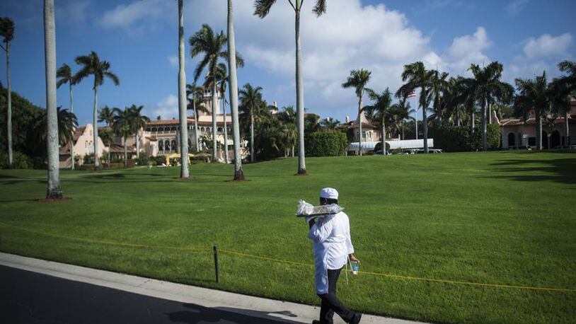 A worker walks the driveway along Mar-a-Lago,  the club and estate owned by President Donald Trump, located in Palm Springs, Florida.