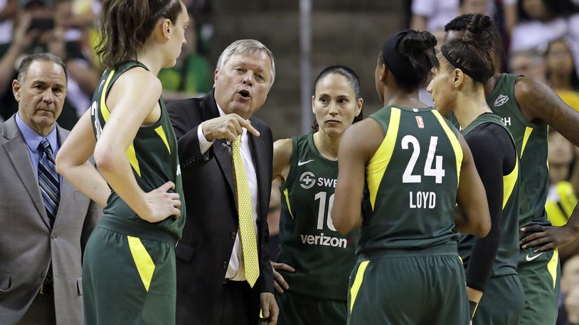 In this Aug. 28, 2018, photo, Seattle Storm head coach Dan Hughes, center, directs his team during a timeout against the Phoenix Mercury in a WNBA basketball playoff semifinal in Seattle. Hughes announced in June 2020 that he wont coach after he was determined to be at higher risk for severe illness if he contracted the coronavirus. The 65-year-old coach missed nine games in 2019 after having a cancerous tumor in his appendix. (AP Photo/Elaine Thompson)