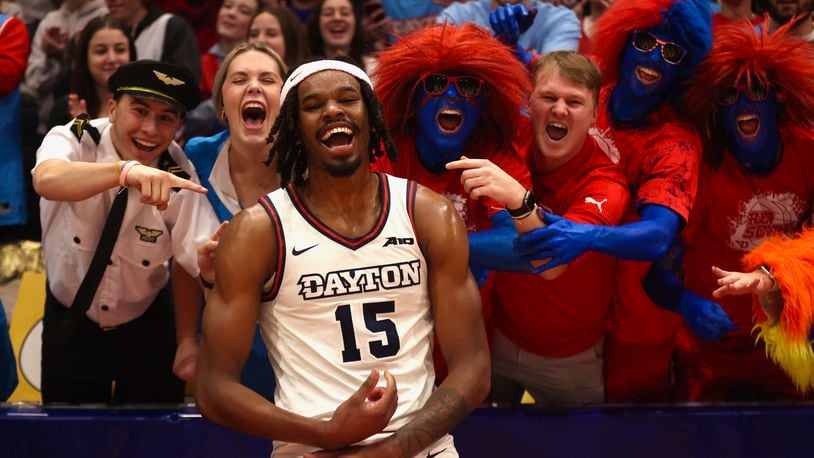 Dayton's DaRon Holmes II celebrates with fans in the Red Scare student section after a victory against Fordham on Saturday, Feb. 17, 2024, at UD Arena. David Jablonski/Staff