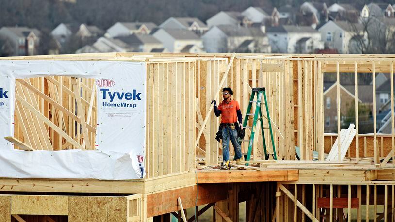 A crew works on construction of a new home in Liberty Twp. NICK GRAHAM/STAFF
